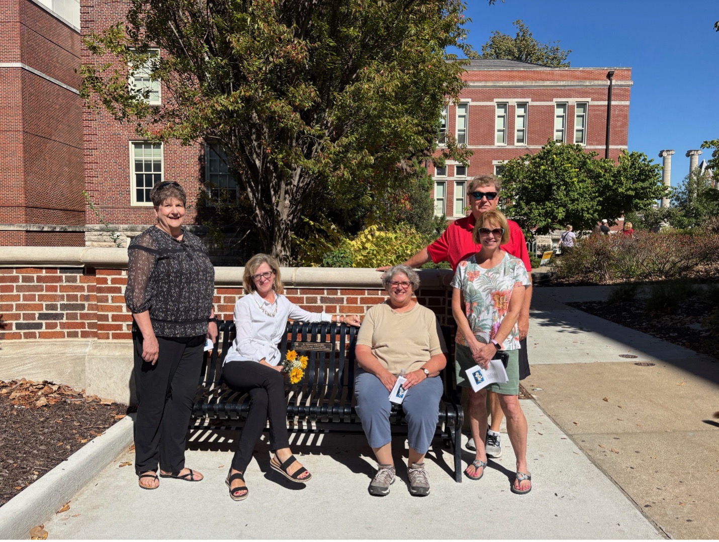 Friends and family gather around the Tribute Bench. 